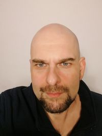 Close-up portrait of man wearing eyeglasses against gray background