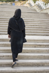 Rear view of woman walking on staircase