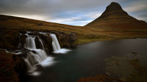 Scenic view of waterfall against sky