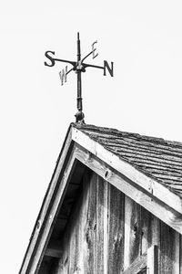 Low angle view of weather vane against sky