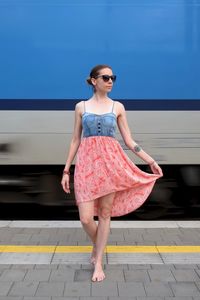 Full length of woman walking against train at railroad station