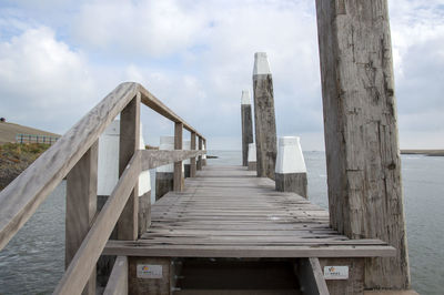 Wooden pier on sea against sky