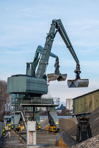 Cranes at construction site against sky