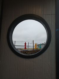 People on glass window against sky