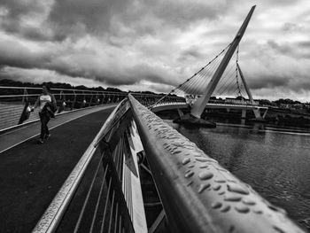 Cropped image of railing against cloudy sky