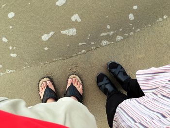 Low section of man standing on sand