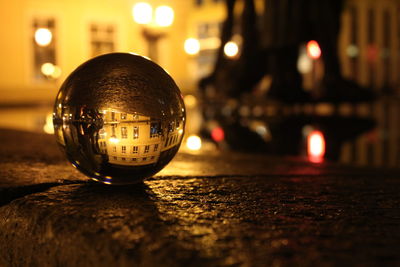 Close-up of illuminated ball on street at night