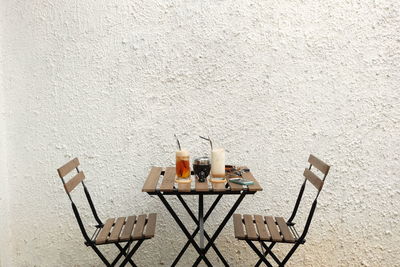 Chairs and tables on table against wall