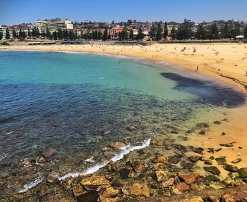 Scenic view of beach by buildings against sky
