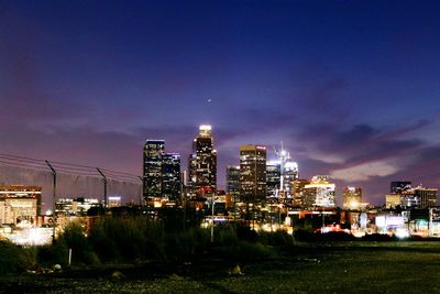 Illuminated cityscape against sky at night