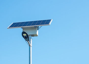 Low angle view of solar panel against clear blue sky