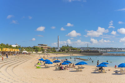 Beach umbrellas and palm trees on the sunset beach in okinawa island in japan.