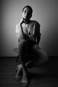 Young man sitting on hardwood floor