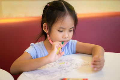 Close-up of a girl looking away while holding table