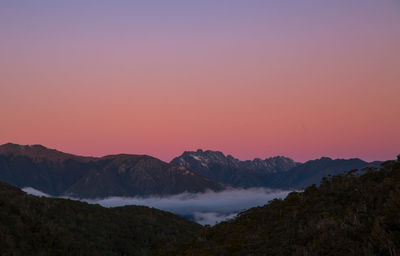 Scenic view of mountains against romantic sky at sunset