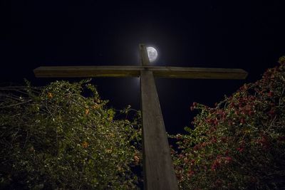 Low angle view of a wooden cross at night