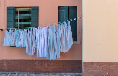 Low angle view of clothes drying against building