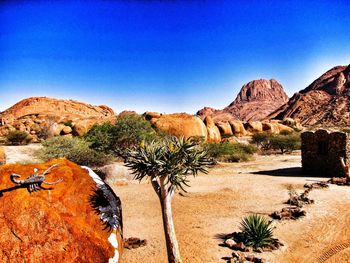 Scenic view of desert against clear blue sky
