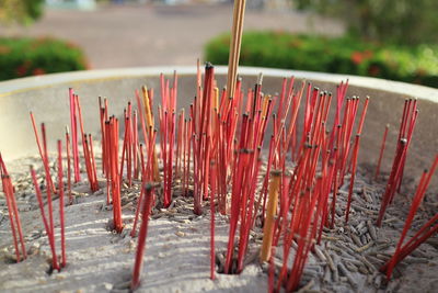 Close-up of red bell outside temple against building
