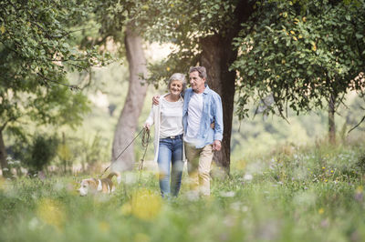 Senior couple on a walk with dog in nature