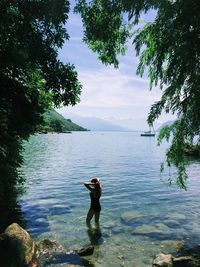 Full length of man standing by lake against sky