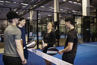 Group of friends talking at indoor padel court