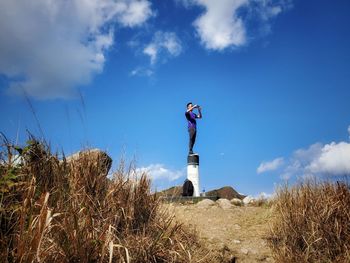 Low angle view of man standing on field against sky