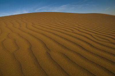 Sand dunes in desert against sky