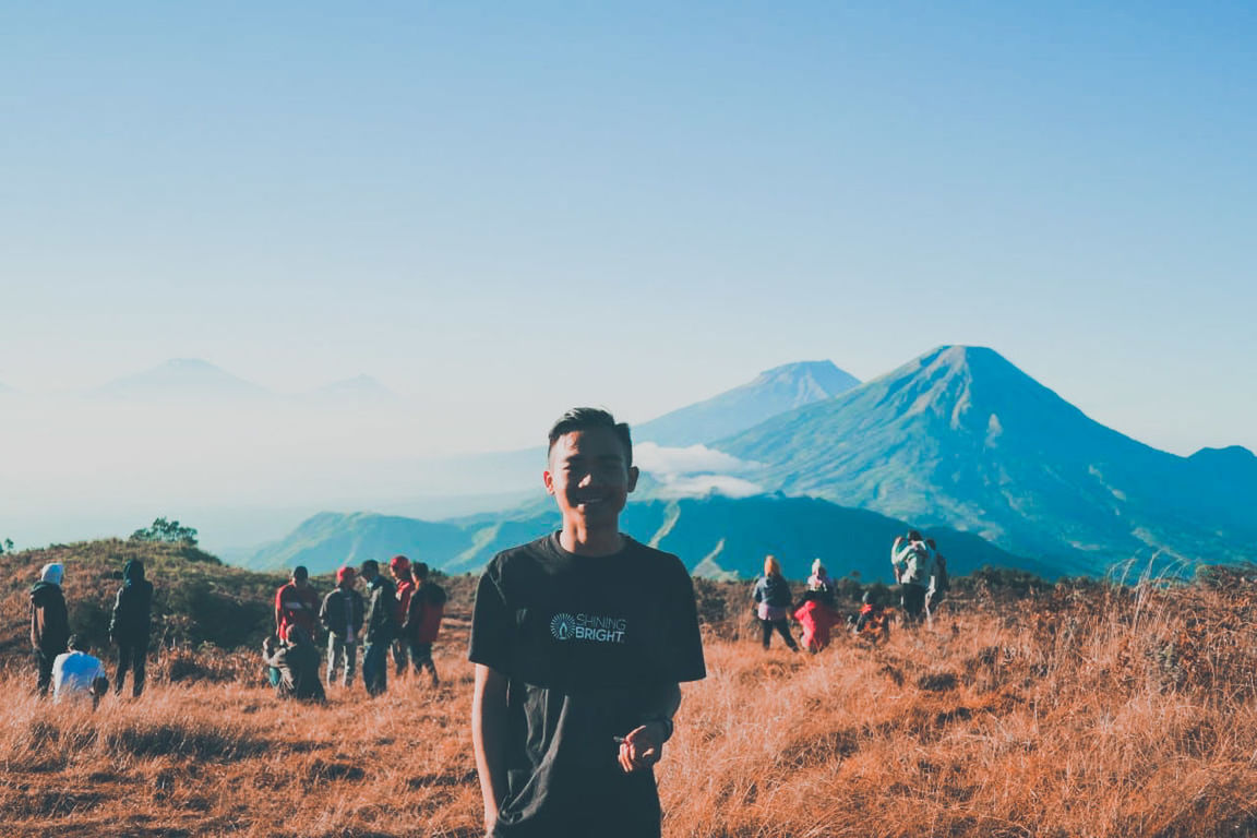 sky, real people, beauty in nature, lifestyles, leisure activity, nature, standing, mountain, clear sky, scenics - nature, young adult, young men, landscape, land, people, copy space, front view, day, tranquility, environment, mountain range, outdoors