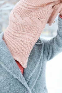 Close-up of person covering face with sweater