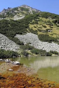 Scenic view of lake by mountain against sky