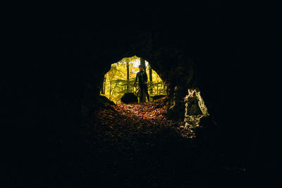 Silhouette people standing in illuminated tunnel