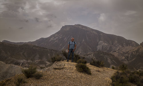 Adult man on tabernas desert in almeria, spain, against cloudy sky