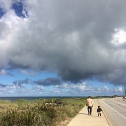 Silhouette of people against cloudy sky