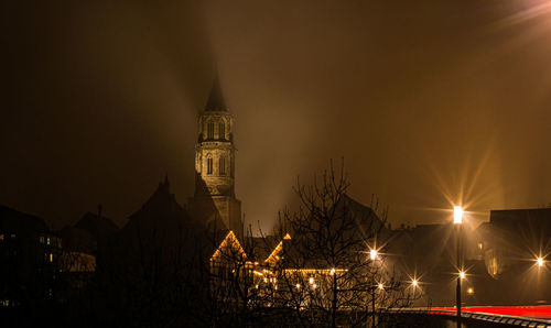 Illuminated buildings against sky at night