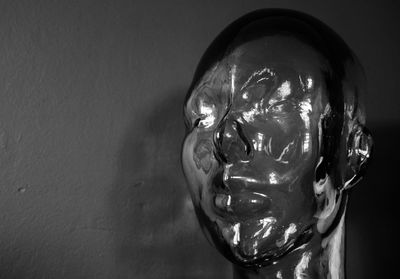 Close-up of illuminated statue against wall