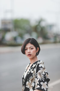 Portrait of woman standing on road against sky