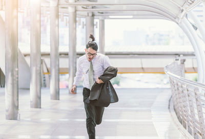 Mid adult businessman running on elevated walkway