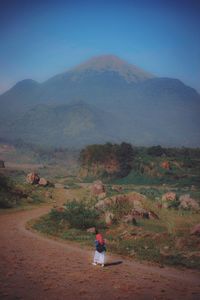 Rear view of woman on landscape against sky