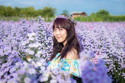 Portrait of beautiful woman standing on field