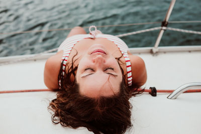 Directly above shot of woman sleeping in boat on sea