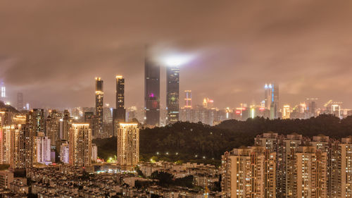 Illuminated buildings in city against sky at night