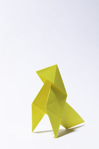 High angle view of yellow paper against white background