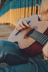 Midsection of woman playing guitar