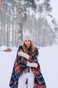 Dancing woman traveling among forest wearing hat and poncho, boho and wanderlust style. winter 