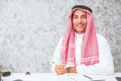 Portrait of smiling businessman in traditional clothing at office