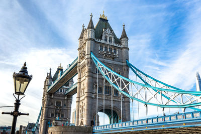 Low angle view of bridge against cloudy sky