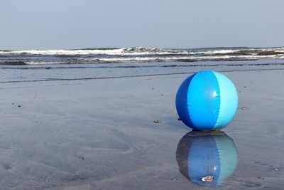 Umbrella on beach against clear sky