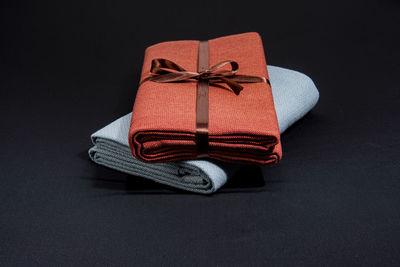 Close-up of box tied up on paper against black background