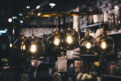 Close-up of illuminated pendant lights hanging in restaurant